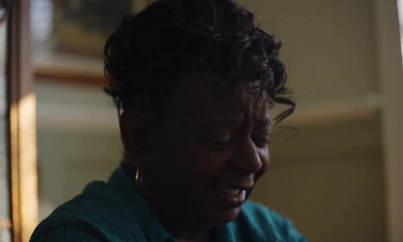 An elderly woman is having a conversation and expressing her emotions in the process