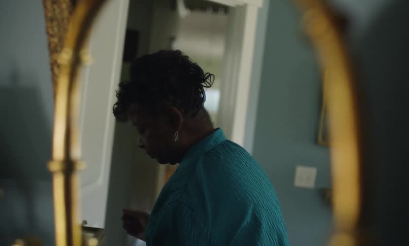 A woman adjusts her hair in the mirror