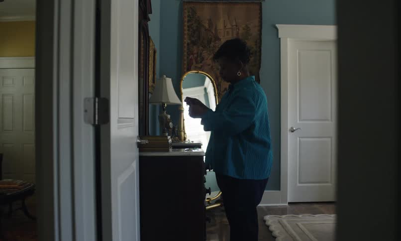 A woman puts on an earring in front of the mirror