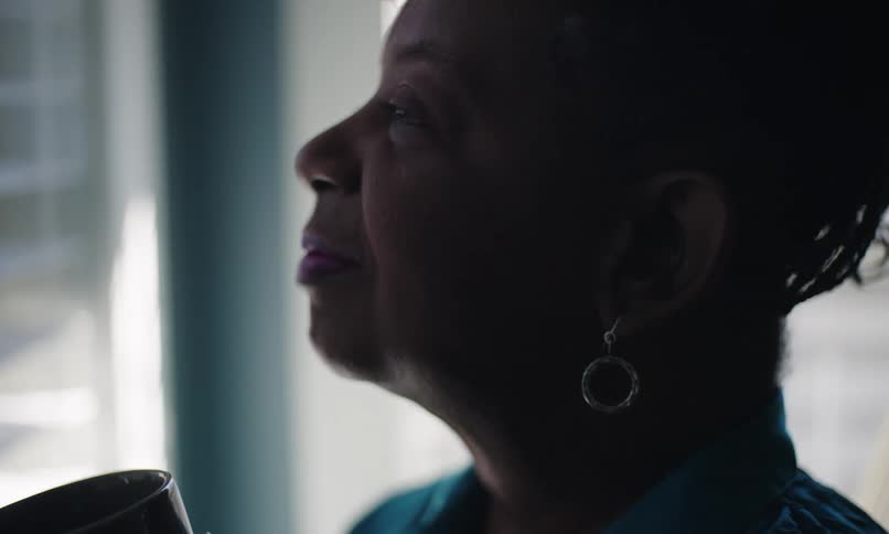 Closeup of a lady looking around thoughtfully and finally taking a sip from her cup