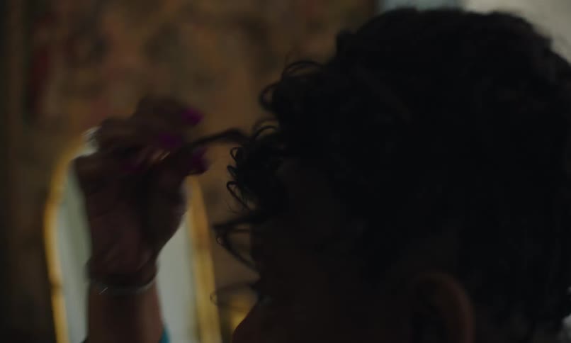 Closeup of a woman adjusting her hair in front of the mirror