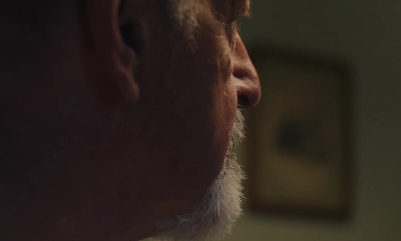 Side portrait of a bearded man washing his face