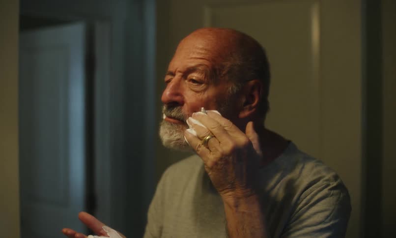 Elderly man passing shaving foam in the bathroom