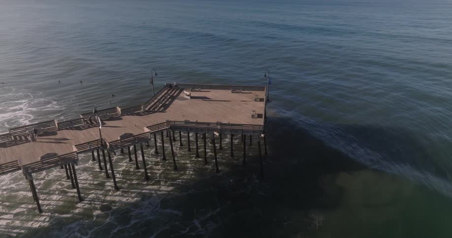 Waves travel to the pier and shore