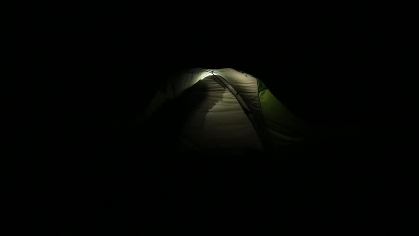 A person sitting inside of a tent