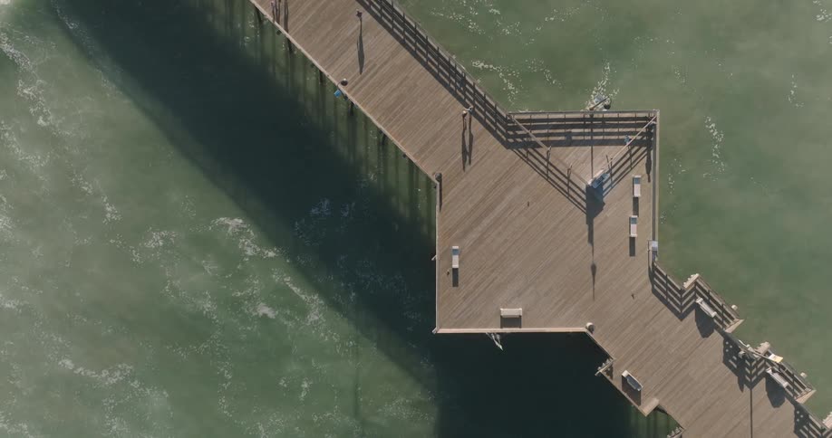 People are walking on the boardwalk of the pier