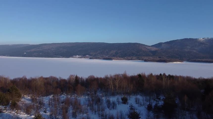 The lake by the mountains is frozen over