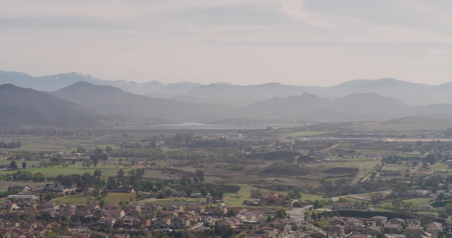 Landscape on a country town with many fields of grass and small houses in background of the montangne