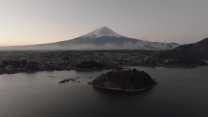 Aerial view of the ocean and in the background a city with an imposing snowy mountain