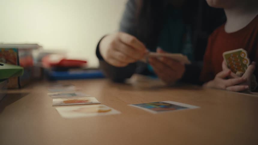 Mom handing out playing cards with her son