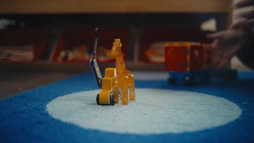 Two children are playing with toys on the carpet