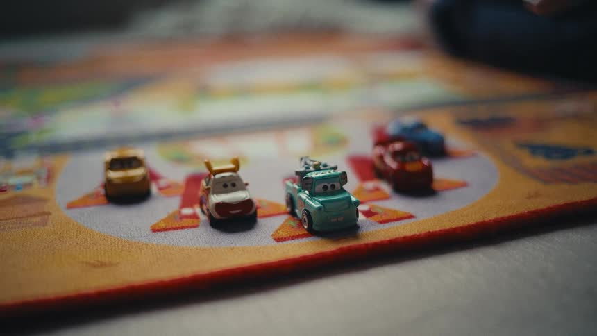 A child points at a toy car on the floor