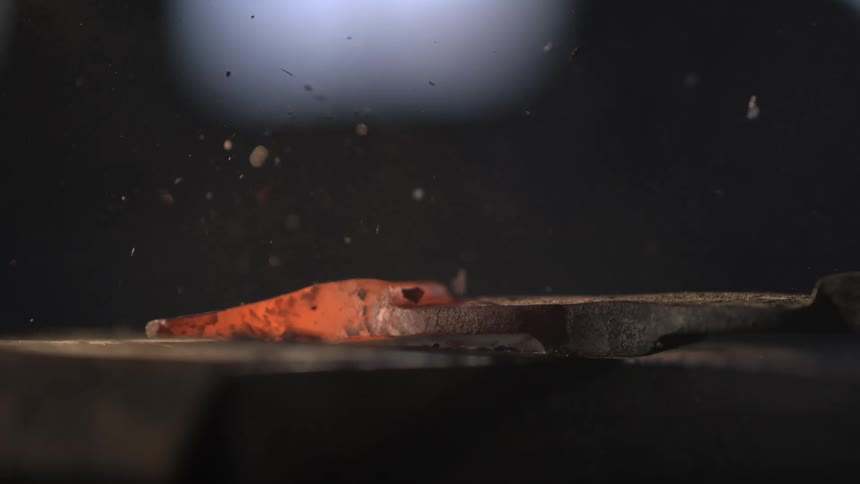 Hot metal is being hammered on the anvil