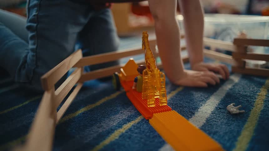 Little boy playing with plastic toy figures on carpeted floor