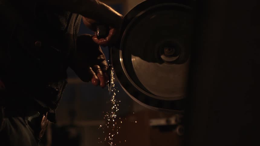 Person working iron with a wheel sander