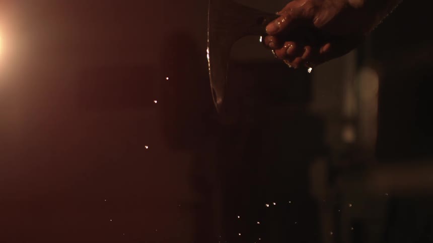 Hand of a man handling a piece of wet iron
