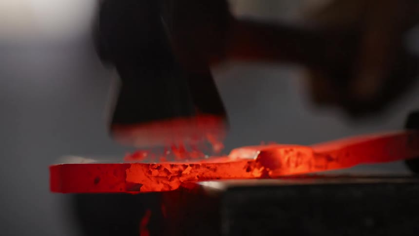 A footage of a person hitting a hot metal