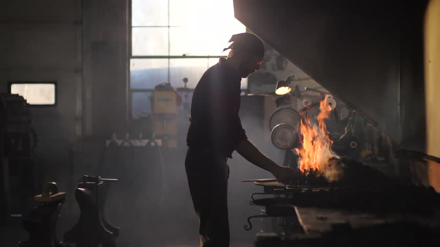 Man working with tools iron with a furnace