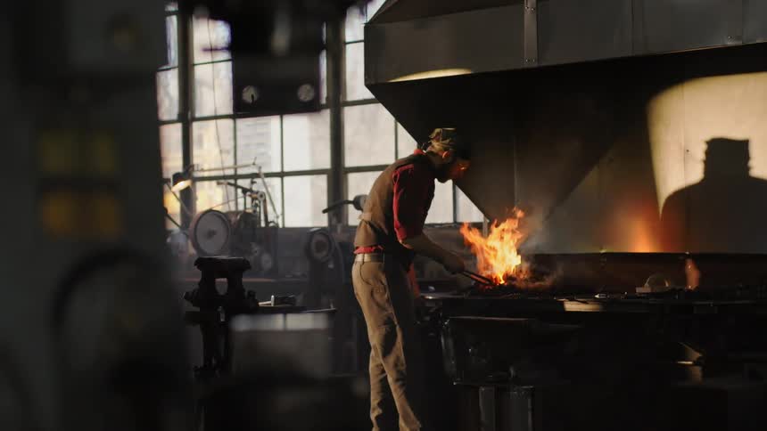 Man stoking fire in a factory