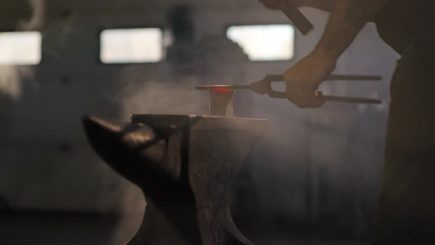 A footage of a blacksmith forging iron