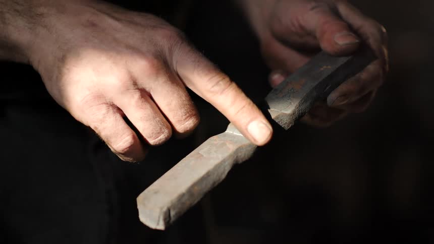A man is working with a metal rod
