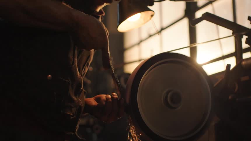 The man is holding something in his hands and then holding it to the grider