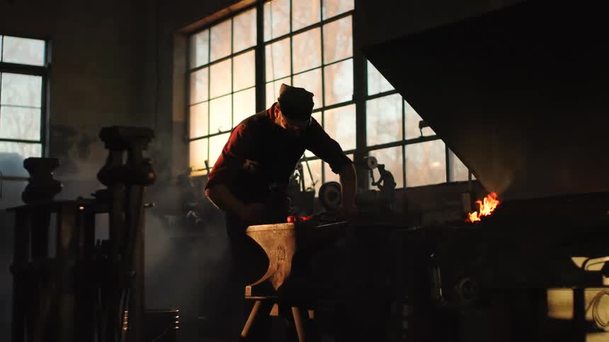 Man beating iron in a factory