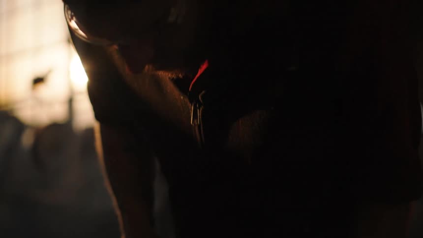 A blacksmith is forging red hot metal on an anvil striking it repeatedly with a hammer