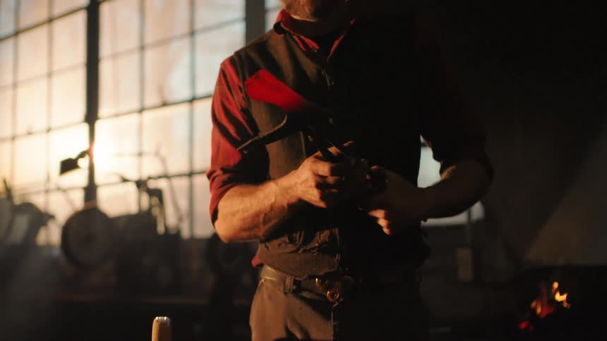 A man is working on a red hot ax