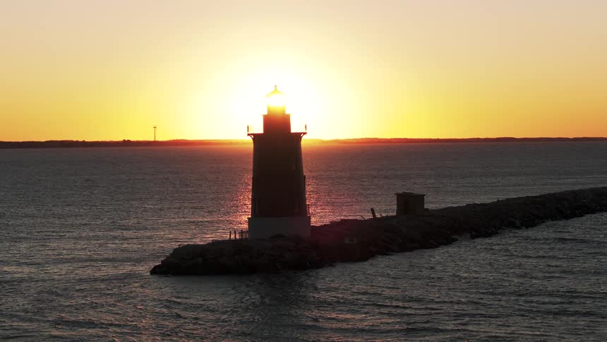 A lighthouse silhouetted against the sunset