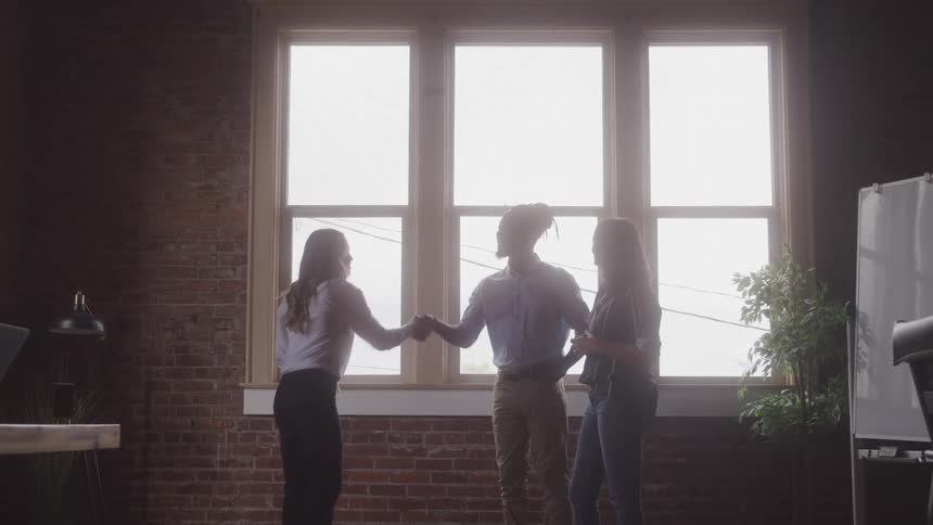 Co workers shake hands in the office