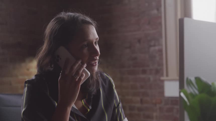 Girl talking on the phone while sitting inside an apartment