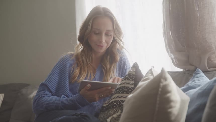 A footage of a lady operating a tablet indoor
