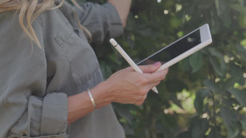 A footage of a lady taking accounts in the garden