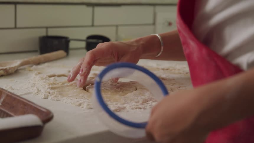 A footage of people molding pastry in the kitchen