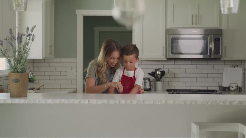 A mother and son are cooking in the kitchen