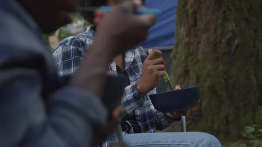 Woman eating next to a man outdoors