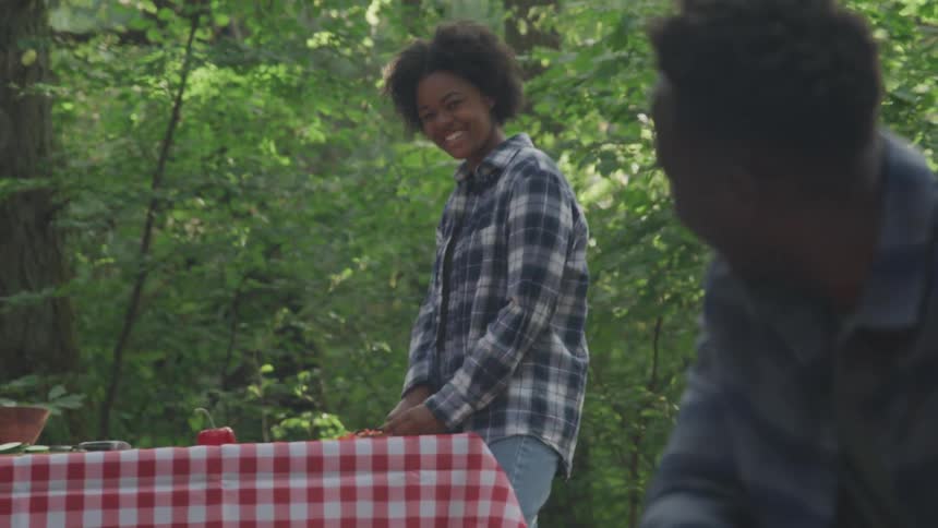 Kids cooking together and smiling in the middle of the woods