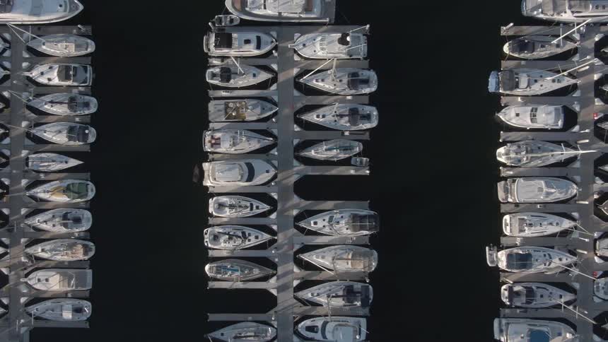 An aerial view of numerous boats neatly docked in rows at a marina
