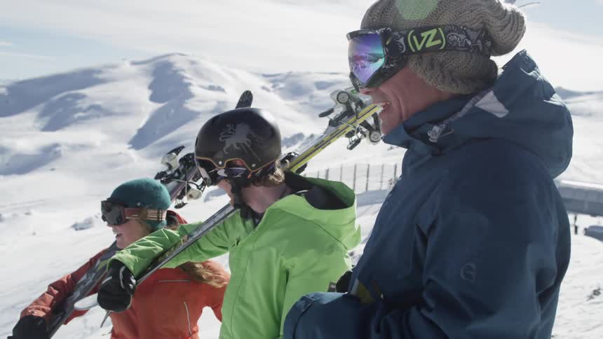 A group of skiers stand on a snow-covered mountain