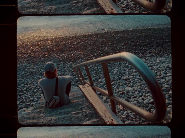 A man is sitting on the steps on the beach