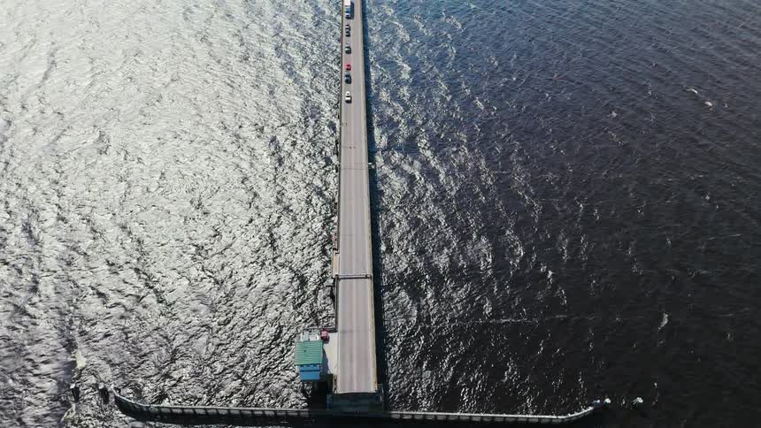 Traffic is stopped on a bridge over open water so a boat can move through
