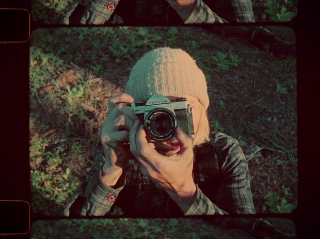 Male photographer looks up and takes a photograph during the day