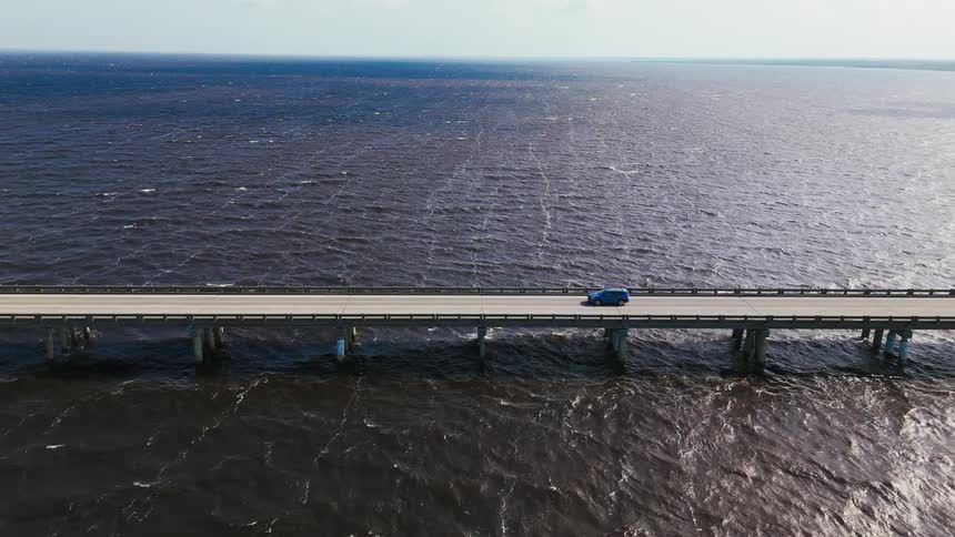 Traffic moves across a long bridge that spans across water