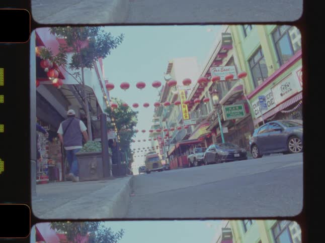 A vibrant street scene with red lanterns vehicles people and colorful buildings