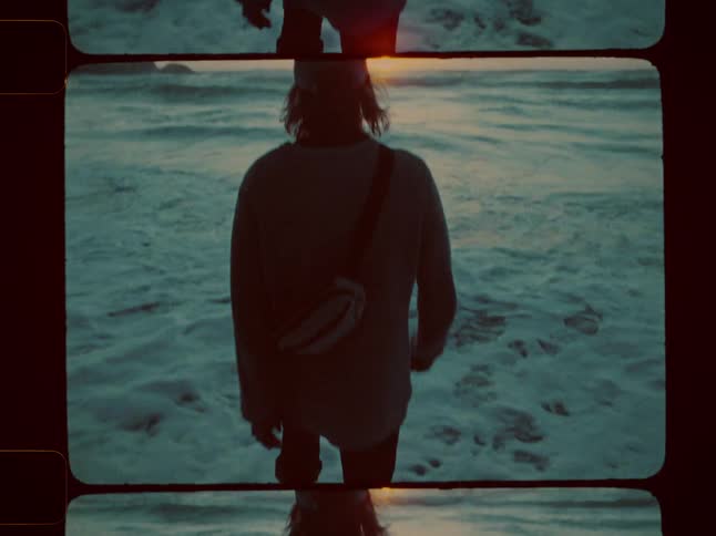 Man wades in foamy waves as the sun rises
