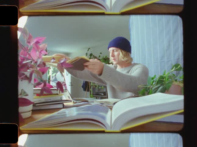 A man is studying with many books around him