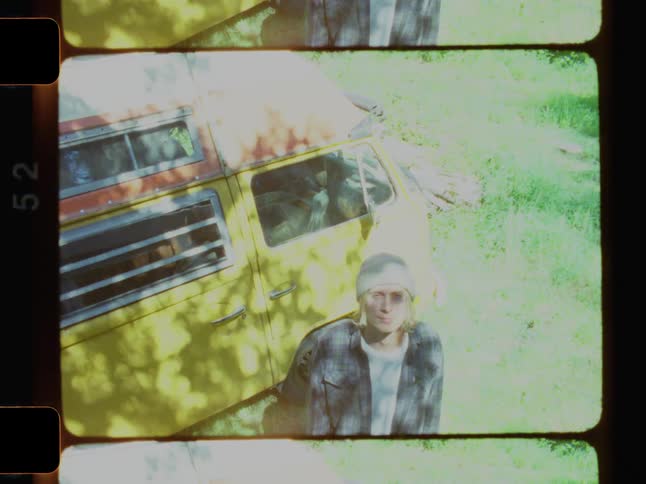 A man is standing outside near the front of his camper van