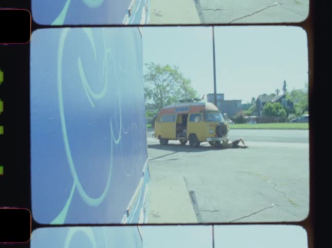 Boy fixing a van outside in a street