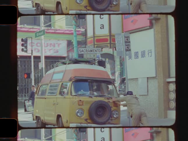 Man pushing a van in the middle of a road